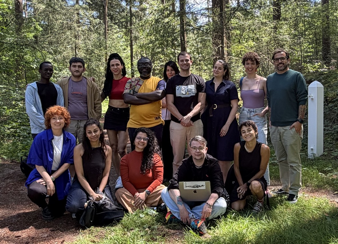 Equipe do Código Não Binário e participantes reunides em foto de grupo em uma floresta na Holanda